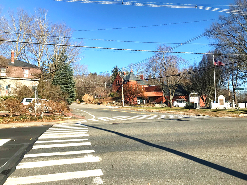 Figure 8 - View across Great Road (Route 117) of Northwest Intersection Corner. Image shows two crosswalks meeting on the street corner where there are two pedestrian detectable warning strips and the sidewalk is made of pavement.